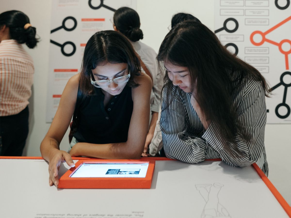 Two persons interacting with the pieces of the Glass Room exhibition.